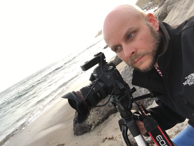 Dariusz Światłowski podczas zdjęć w Malibu w Kalifornii. Na zdjęciu przygotowuje aparat Canon do pracy. Zdjęcia na plaży